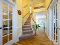 Bright foyer with wood floors, staircase, and transom windows, creating an open and welcoming entrance at 6311 Red Maple Dr, Charlotte, NC 28277