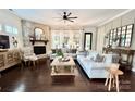Cozy living room featuring a stone fireplace, hardwood floors, and large windows providing natural light at 7076 Brookstone Ln, Fort Mill, SC 29707