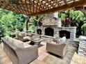 Covered patio featuring an outdoor stone fireplace and comfortable seating for entertaining guests at 7076 Brookstone Ln, Fort Mill, SC 29707
