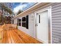 A close-up of a wooden porch, front door and window with black shutters at 716 Sharon Ln, Iron Station, NC 28080