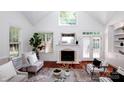 Bright living room featuring a cozy fireplace, soaring ceilings, and hardwood floors at 7554 Bluestar Ln, Charlotte, NC 28226