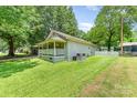 Well-maintained home featuring lush green lawn, vinyl siding, and partial fencing at 909 Lakeview St, Kannapolis, NC 28083