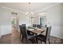 Open dining room with hardwood floors, decorative wainscoting, and a view to the living areas at 10437 Paper Birch Dr, Charlotte, NC 28215