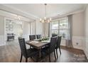 Elegant dining room with modern chandelier, a large window, and stylish gray chairs at 10437 Paper Birch Dr, Charlotte, NC 28215