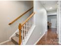 Bright staircase with carpeted steps, white risers, and a wood railing leading to the upper level at 11521 Savannah Creek Dr, Charlotte, NC 28273