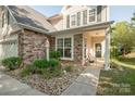 Inviting front porch with decorative stone accents, small garden, and cozy seating area at 1304 Hammond Dr, Matthews, NC 28104
