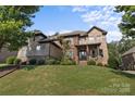 Beautiful stone home features a well-manicured lawn and a charming covered front porch at 16522 Flintrock Falls Ln, Charlotte, NC 28278