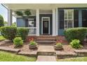 Close-up of the house's entryway with a charming front porch, flower pots and healthy shrubs at 17711 North Shore Cir, Cornelius, NC 28031