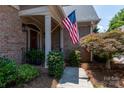 Front porch with decorative bushes and an American flag at 18534 Carnegie Overlook Blvd # 110, Davidson, NC 28036
