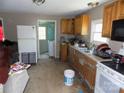 Kitchen interior with dated cabinets, appliances, and cluttered countertops; needs renovation at 212 Huffman Rd, Gastonia, NC 28052
