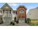 Townhouse with single garage, light siding, dark shutters, and a brick accent above the garage at 2137 Whispering Way, Charlotte, NC 28212