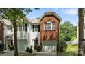 A charming townhome with white siding and a brick accent wall above the attached garage at 2137 Whispering Way, Charlotte, NC 28212