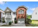 Townhouse with white siding, dark shutters, a brick accent over the garage, and a paved driveway at 2137 Whispering Way, Charlotte, NC 28212