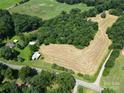 Expansive aerial view of a rural property with fields, scattered barns, and dense woodlands at 233 Hicks Rd, Statesville, NC 28625