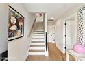 Bright entryway features hardwood floors, white staircase, and modern artwork at 3006 Khan Park Dr # 69, Charlotte, NC 28206