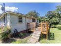 A wooden deck, accessible by stairs, offers a cozy outdoor space, next to a small side yard at 3419 Boat Club Rd, Belmont, NC 28012