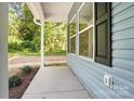 The inviting front porch showcasing the home's exterior with blue siding and black shutters at 411 Patience Dr, Concord, NC 28025