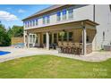 Covered outdoor seating area with a built-in bar, perfect for entertaining and enjoying the pool at 5105 Paisano Ln, Waxhaw, NC 28173