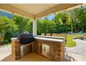 Outdoor kitchen area featuring stone accents and stainless steel storage, ideal for al fresco dining at 5105 Paisano Ln, Waxhaw, NC 28173