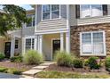Close-up of a townhouse entrance featuring stone detailing, lush landscaping, and a welcoming walkway at 514 Bent Leaf Ct, Fort Mill, SC 29708