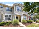 Inviting townhouse facade with stone accents, a covered porch, and manicured landscaping at 514 Bent Leaf Ct, Fort Mill, SC 29708