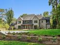 Beautiful home with landscaped yard, stone accents, and a well-maintained green lawn at 5311 Carmel Park Dr, Charlotte, NC 28211