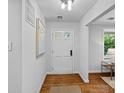 Bright entryway featuring a white door with glass panes, hardwood floors, and neutral decor at 5441 Wintercrest Ln, Charlotte, NC 28209