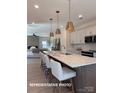 Open kitchen with a large island, pendant lighting, white cabinets, and stainless steel appliances at 728 Falling Oak Aly # 21, Huntersville, NC 28078