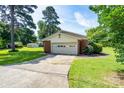 Detached two car garage with brick accents and a paved driveway in a serene setting at 938 Kannapolis Pkwy, Concord, NC 28027