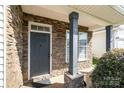 Stone-accented entryway with a dark front door, window, and stately columns create inviting curb appeal at 9644 Marquette Nw St, Concord, NC 28027