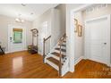 Bright foyer with hardwood floors, staircase and a decorative coat rack at 1108 Mayapple Way, Belmont, NC 28012