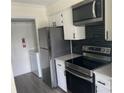 Modern kitchen featuring stainless steel appliances, black backsplash, and white cabinets at 11123 Harrowfield Rd, Charlotte, NC 28226