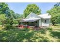 View of the back of the house with covered porch and lush green surroundings at 1173 Cat Square Rd, Vale, NC 28168