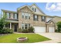 Charming two-story home with a well-maintained lawn, a cozy fire pit, and a two-car garage at 1281 Arges River Dr, Fort Mill, SC 29715