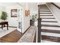 Inviting foyer featuring hardwood floors, elegant staircase, decorative rug, and classic wainscoting at 154 Cotton Field Dr, Statesville, NC 28677