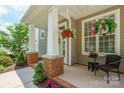 Inviting front porch with brick accents, hanging flower baskets, and a cozy seating area at 20444 Greenway Heights Dr, Cornelius, NC 28031