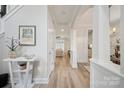 Bright hallway with hardwood floors, white trim, arched doorway, and decorative accents at 20444 Greenway Heights Dr, Cornelius, NC 28031