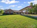Lovely brick home with well-manicured lawn and extended covered parking area at 3206 Basilwood Cir, Monroe, NC 28110