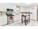 Bright kitchen featuring white cabinets, stainless steel appliances, and a breakfast table at 3711 Davis Dr, Charlotte, NC 28270