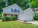 Charming two-story home with well-manicured lawn, garage, and a welcoming facade with lush green trees at 3830 Brookchase Ln, Charlotte, NC 28205