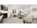 Airy living room with fireplace, modern furniture, large windows and view to the kitchen at 3901 Coleman Dr, Charlotte, NC 28215