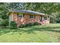 Quaint brick house with a well-kept lawn, and black window shutters adding charm at 408 Kennerly Dr, Indian Trail, NC 28079