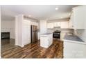Bright kitchen featuring white cabinets, stainless steel appliances, and a functional center island on stylish laminate flooring at 508 Bridgestone Ln, Rock Hill, SC 29730