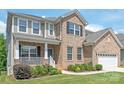 Charming two-story brick home with a manicured lawn, cozy porch, and landscaped yard at 6320 Tilley Way, Matthews, NC 28105