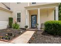 Inviting front porch with neat landscaping and a blue front door at this lovely home at 6422 Gatesville Ln, Charlotte, NC 28270