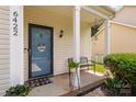 Quaint covered front porch with welcome sign on a lovely blue glass front door at 6422 Gatesville Ln, Charlotte, NC 28270