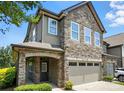 Charming two-story townhome featuring a stone facade, covered entryway, and attached two-car garage at 809 Ayrshire Ave, Fort Mill, SC 29708