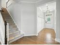 Bright foyer featuring hardwood floors, staircase with carpet runner, and front door with transom window at 809 Ayrshire Ave, Fort Mill, SC 29708