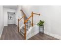 Elegant staircase featuring wooden handrails and white spindles, complemented by stylish floors at 9720 Walkers Glen Nw Dr, Concord, NC 28027