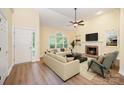 Bright living room with vaulted ceiling, fireplace, large windows, and modern furnishings, offering a cozy and inviting atmosphere at 975 Pine Knoll Rd, Fort Mill, SC 29715